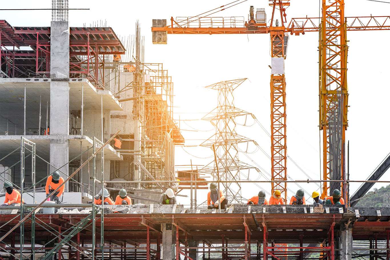 Workers are working on large construction sites and many cranes